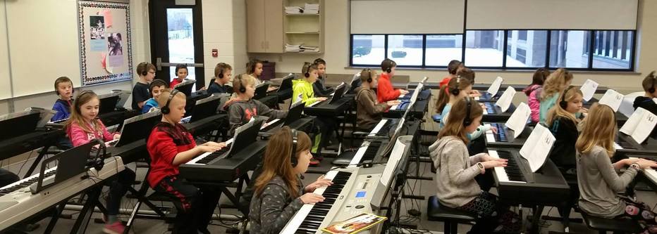 Students playing keyboards in the music room